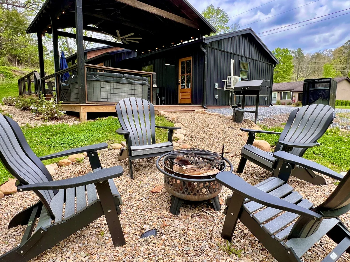 This image features a fire pit surrounded by classic Adirondack chairs on a deck, suggesting a cozy and inviting outdoor space ideal for social gatherings, marshmallow roasting, and family conversations under the stars.